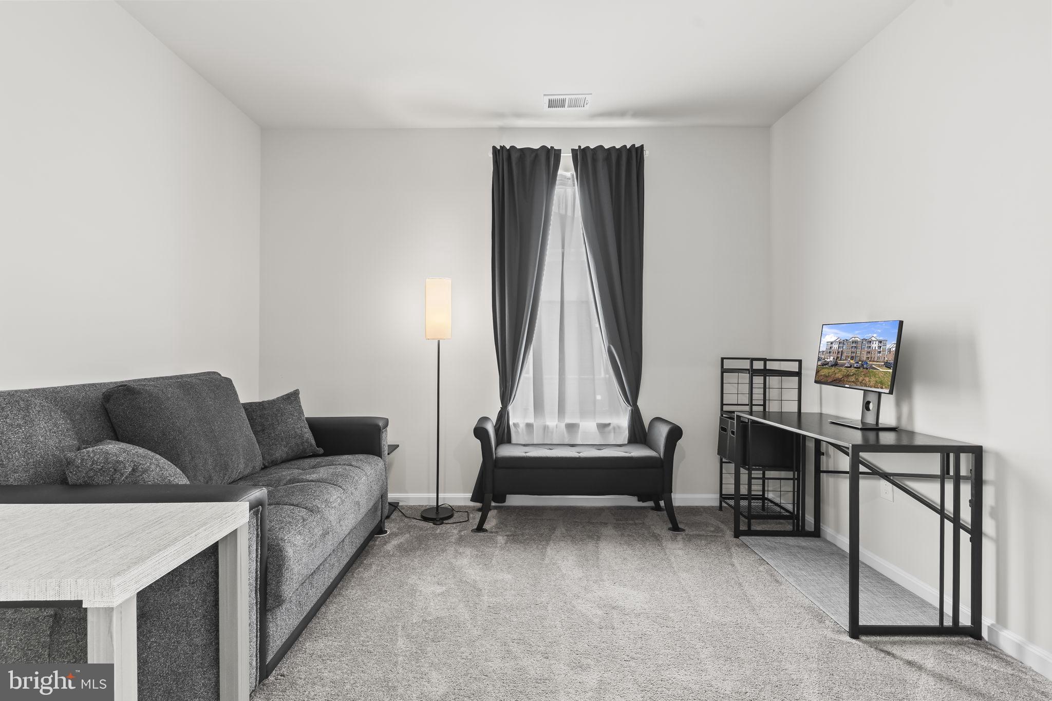 4007 Seaside Alder Road, Unit 8307 Bowie, MD 20720 - Photo 14 of 32 a living room with furniture and a night stand