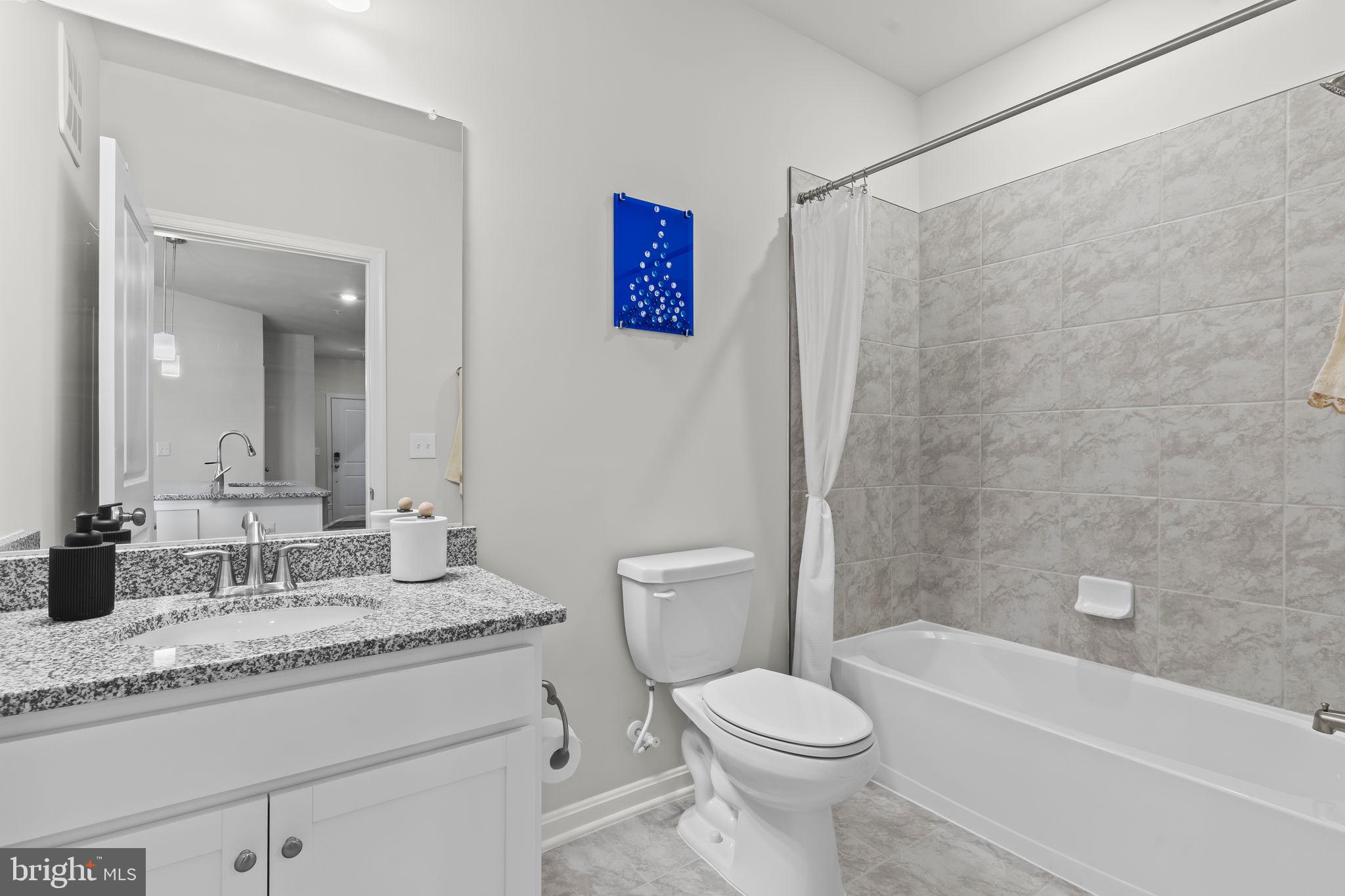 4007 Seaside Alder Road, Unit 8307 Bowie, MD 20720 - Photo 16 of 32 a bathroom with a granite countertop sink toilet and shower