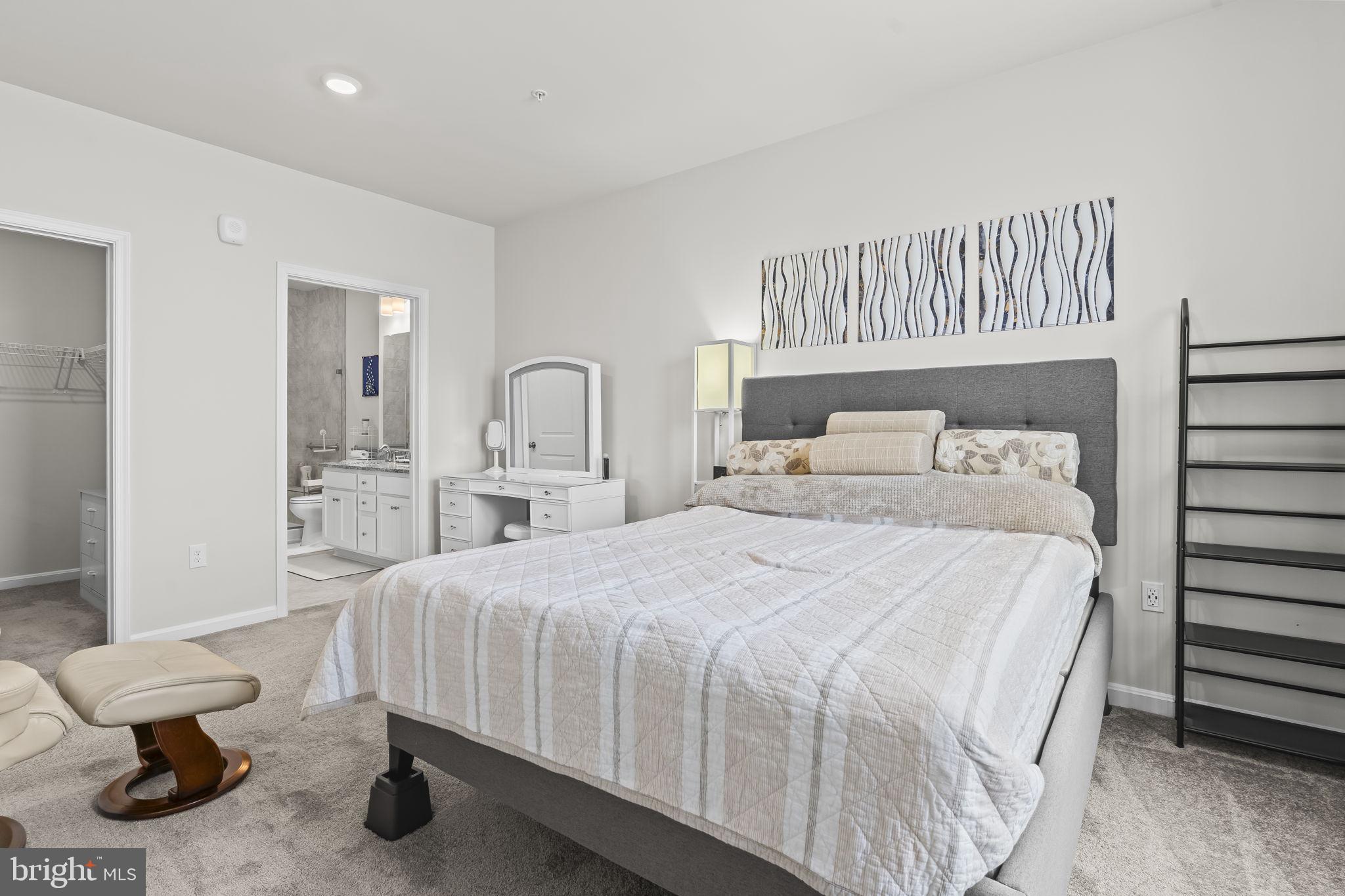 4007 Seaside Alder Road, Unit 8307 Bowie, MD 20720 - Photo 19 of 32 a bedroom with a bed and a large mirror with the dresser