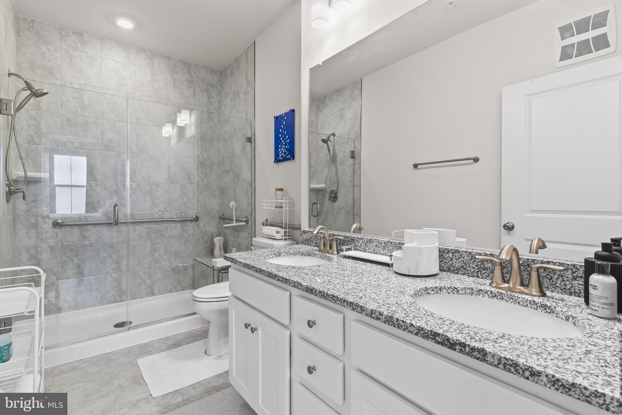 4007 Seaside Alder Road, Unit 8307 Bowie, MD 20720 - Photo 21 of 32 a bathroom with a granite countertop double vanity sink a mirror and a bathtub