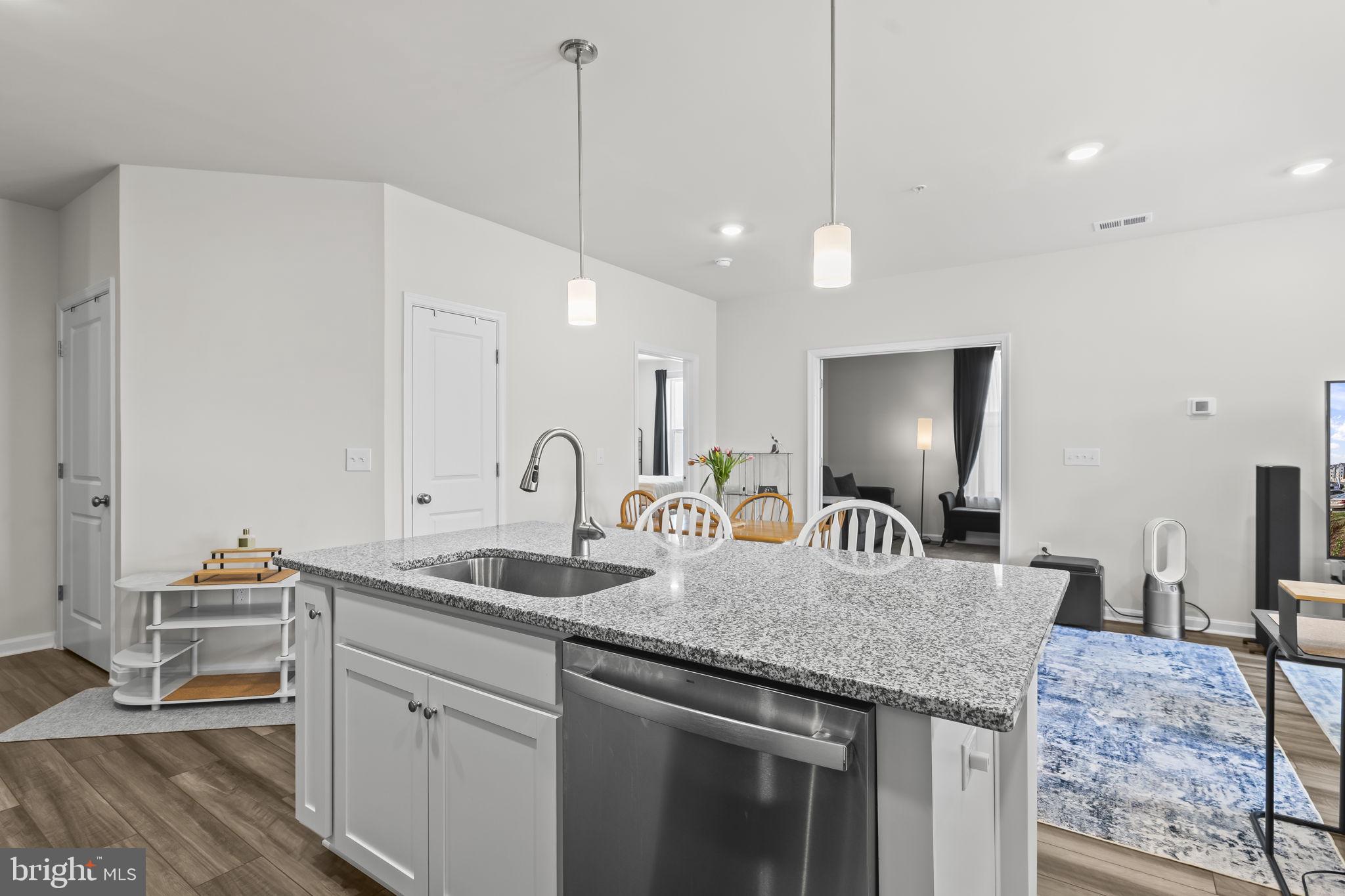 4007 Seaside Alder Road, Unit 8307 Bowie, MD 20720 - Photo 6 of 32 a kitchen with kitchen island granite countertop a sink a center island and cabinets