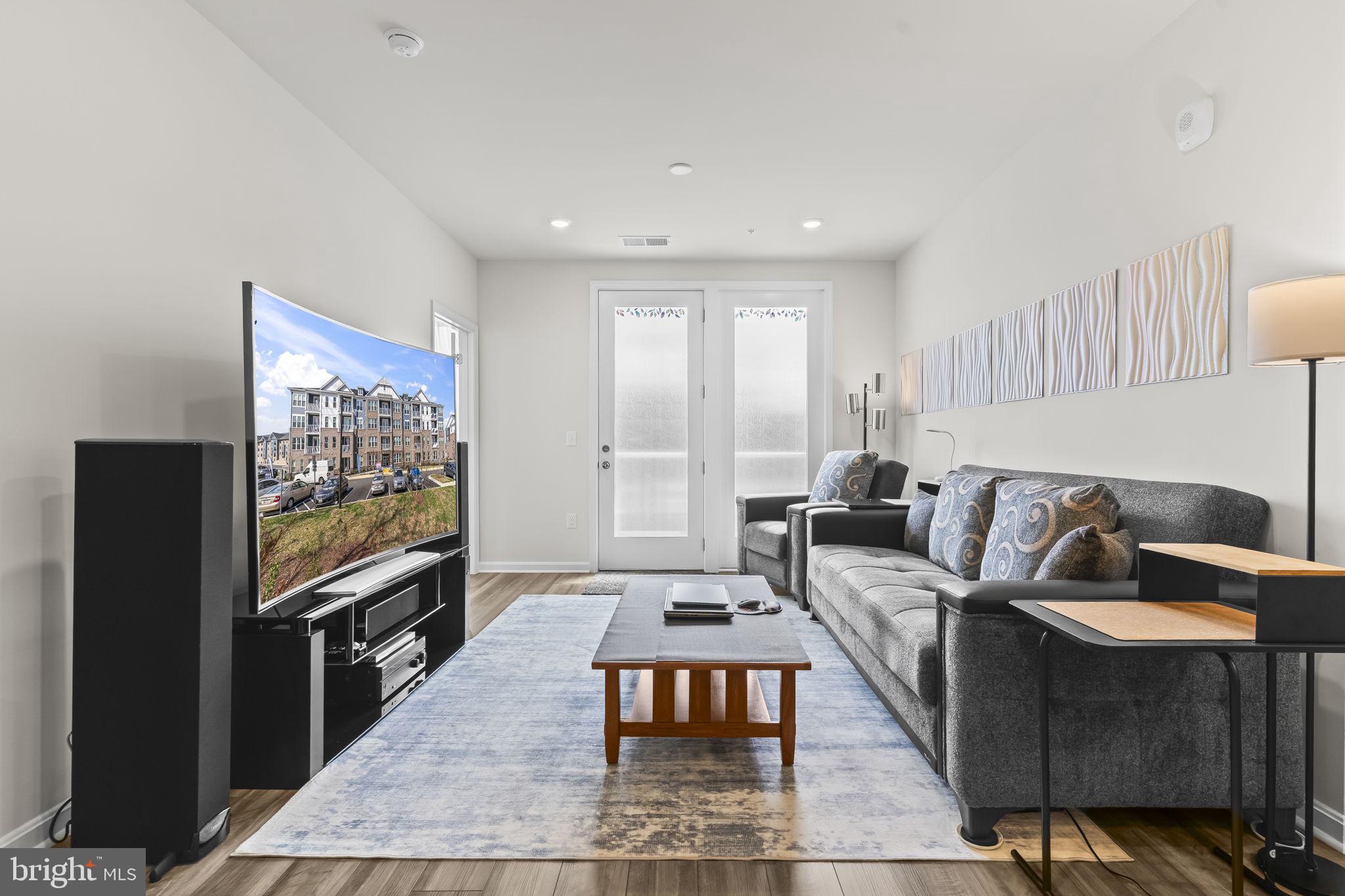 4007 Seaside Alder Road, Unit 8307 Bowie, MD 20720 - Photo 9 of 32 a living room with furniture and a flat screen tv