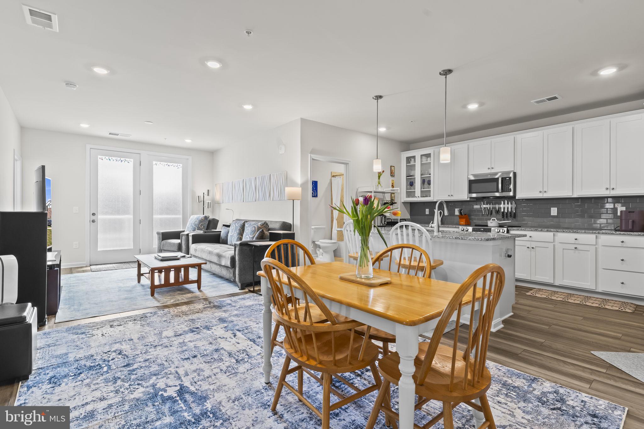 4007 Seaside Alder Road, Unit 8307 Bowie, MD 20720 - Photo 10 of 32 a dining room with stainless steel appliances kitchen island granite countertop a dining table chairs and view kitchen
