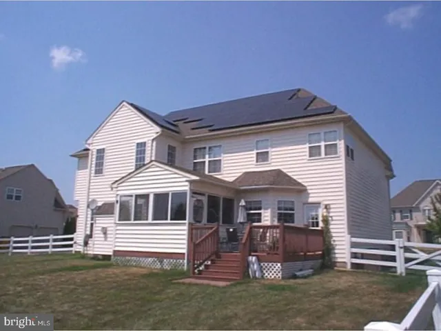 a view of a green field with wooden fence