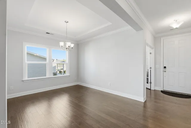 an empty room with windows and fireplace