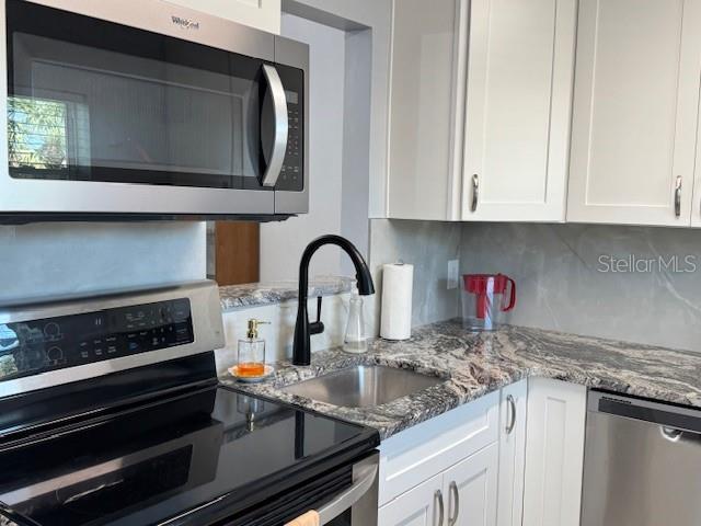 11485 Oakhurst Road, Unit 319 Largo, FL 33774 - Photo 21 of 63 a kitchen with stainless steel appliances granite countertop a stove and a white cabinets