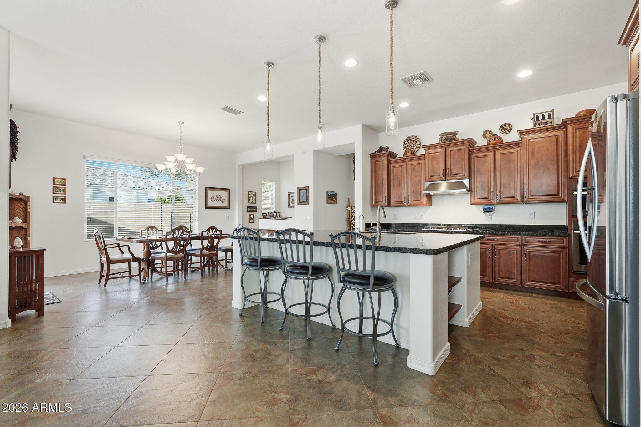 20066 East Russet Road Queen Creek, AZ 85142 - Photo 20 of 59 a kitchen with stainless steel appliances kitchen island granite countertop a table chairs and a refrigerator