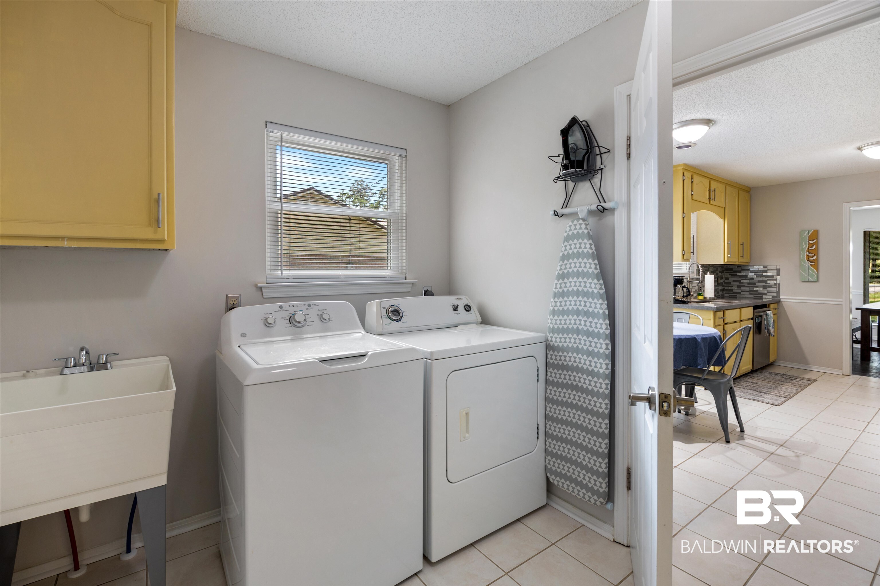 9771 Clarke Ridge Road Foley, AL 36535 - Photo 39 of 72 Washroom with washing machine and clothes dryer, a wealth of natural light, a sink, and cabinet space.