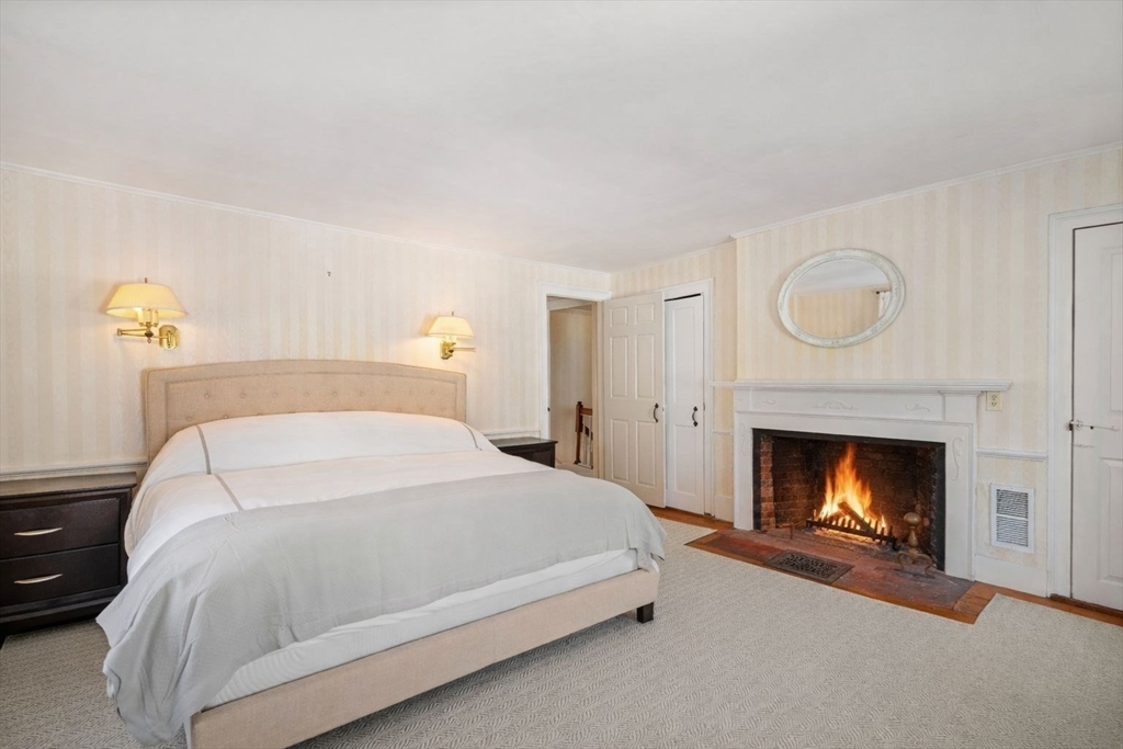 45 School Street Manchester, MA 01944 - Photo 29 of 42 a bedroom with a bed and a fireplace