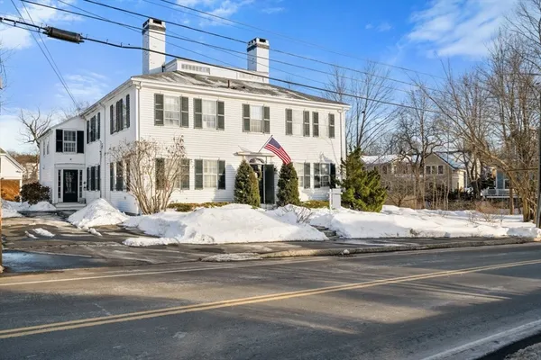 a open kitchen with stainless steel appliances granite countertop a stove top oven a dining table and chairs with wooden floor