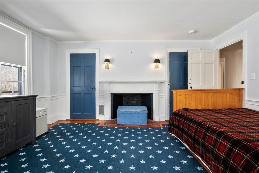 45 School Street Manchester, MA 01944 - Photo 36 of 42 a bedroom with a bed and a fireplace