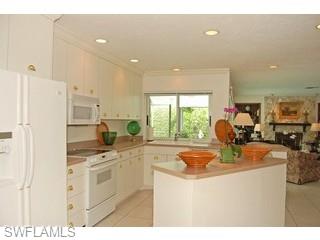 4356 Crayton Road Naples, FL 34103 - Photo 6 of 8 a kitchen with stainless steel appliances granite countertop a sink stove and refrigerator