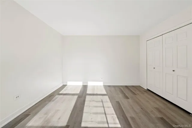 a view of a room with a white wall and a window