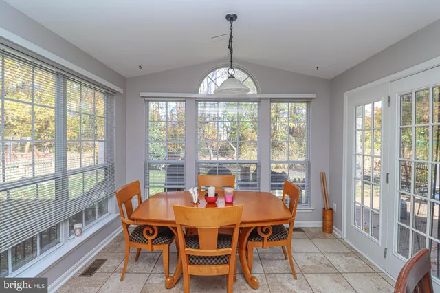 a dining room with furniture a chandelier and window