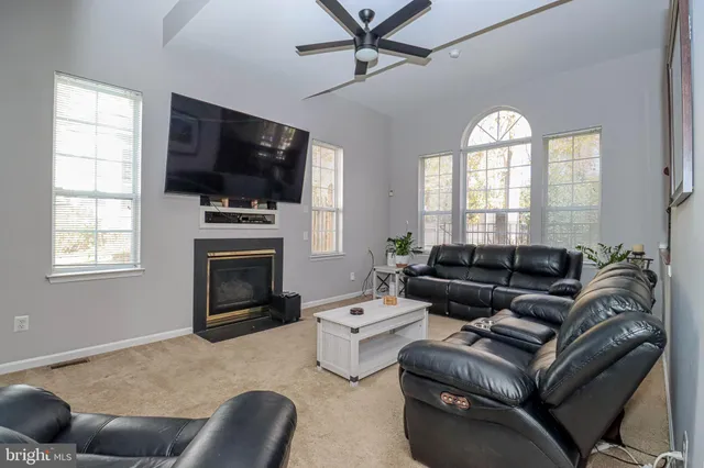 a living room with furniture fireplace and a large window