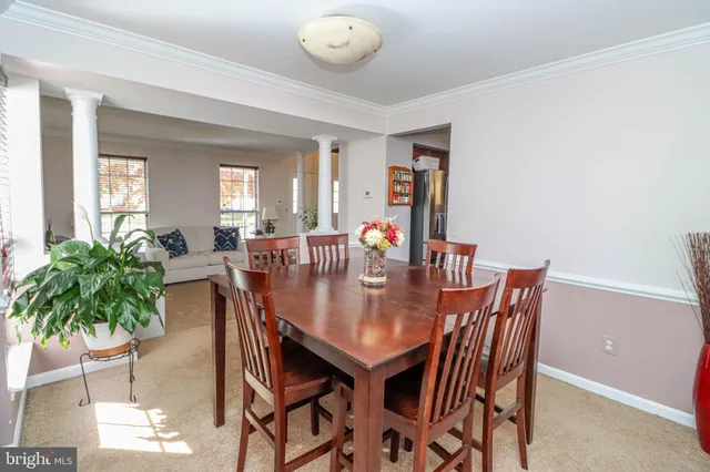 a kitchen with stainless steel appliances a sink a stove a refrigerator cabinets and dining table