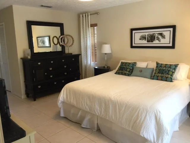 a bedroom with a bed and lamp on dresser