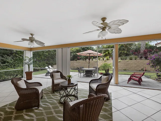 a living room with patio furniture and a large window