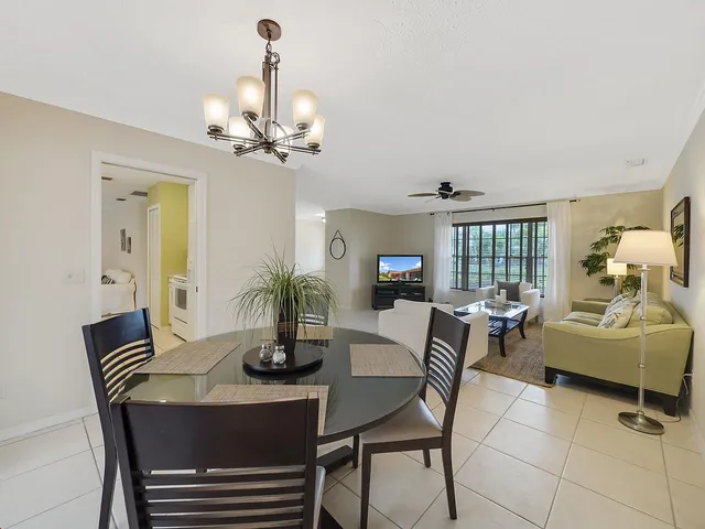 a dining room with furniture a chandelier and window