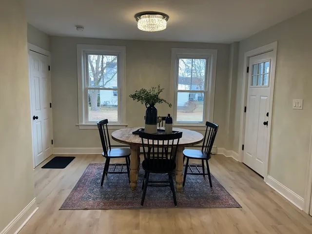 a dining room with furniture a rug and wooden floor