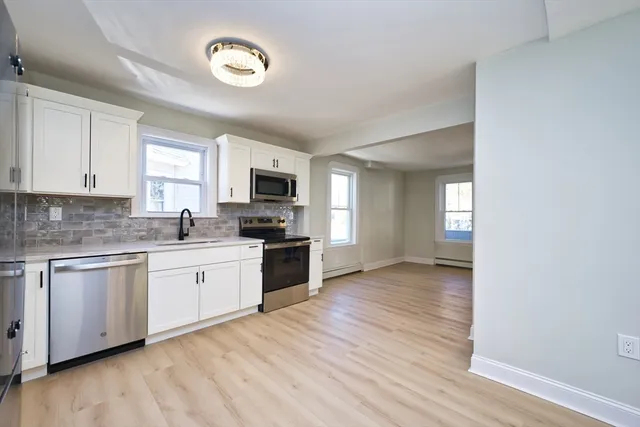 a kitchen with granite countertop a stove top oven sink and cabinets