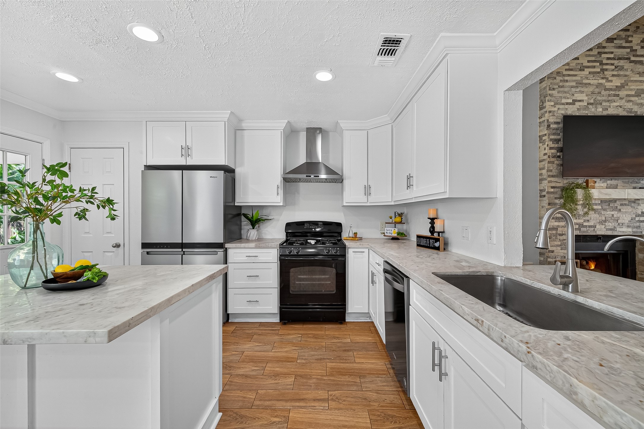 5323 Windsong Trail Houston, TX 77084 - Photo 3 of 30 Beautifully remodeled in 2024, this bright kitchen features quartz countertops, custom white cabinetry, and a sleek vent hood.