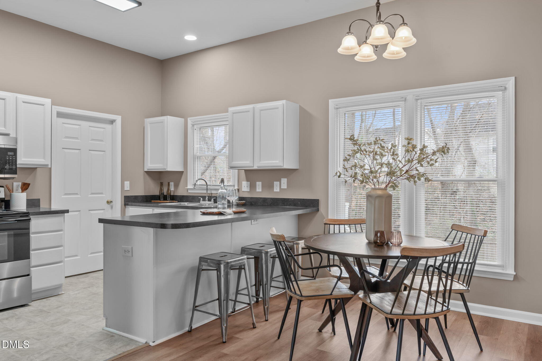 420 Johnson Street Garner, NC 27529 - Photo 13 of 43 a kitchen with stainless steel appliances granite countertop a dining table chairs and white cabinets