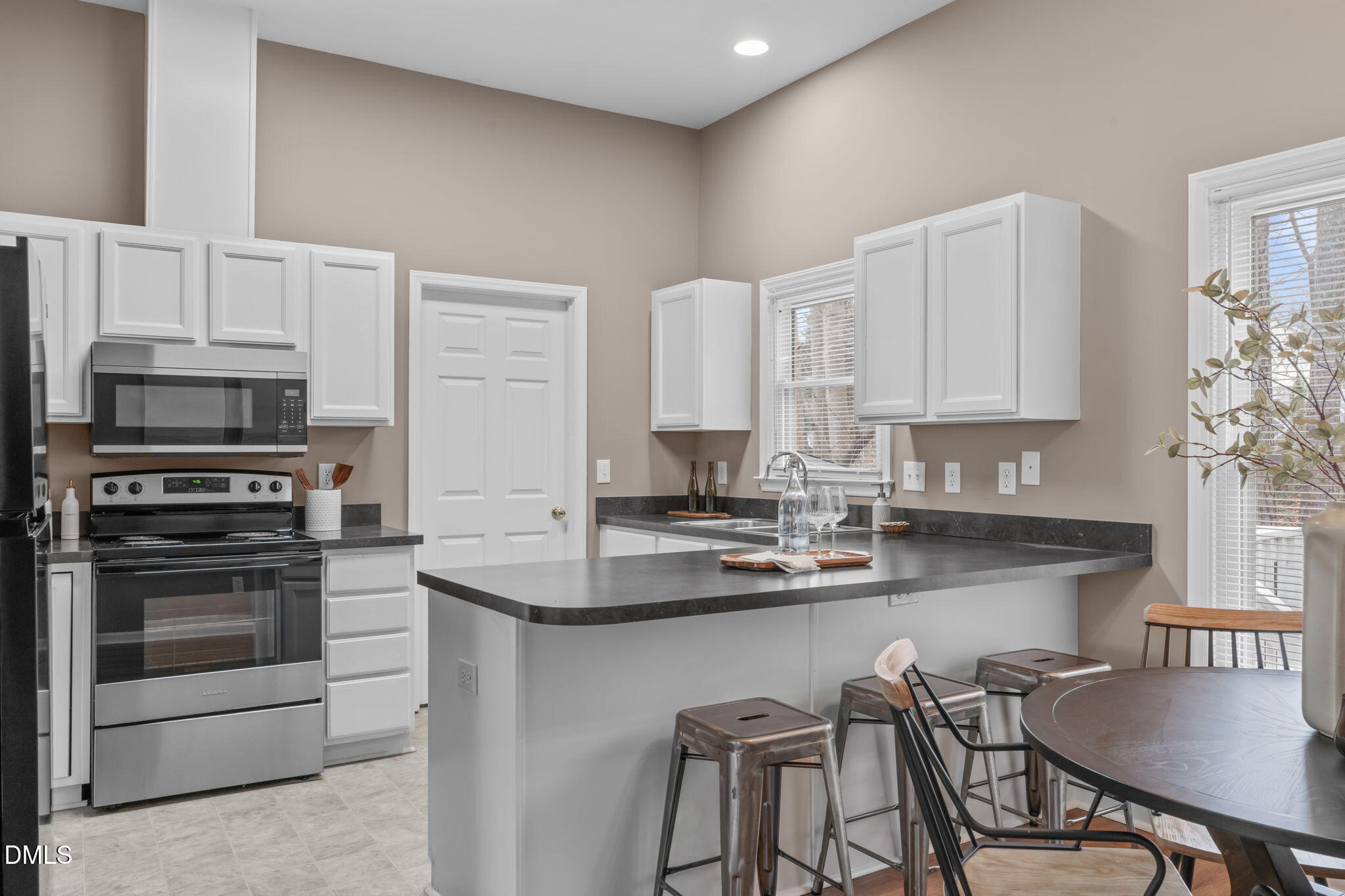 420 Johnson Street Garner, NC 27529 - Photo 14 of 43 a kitchen with stainless steel appliances a stove a sink island and chairs
