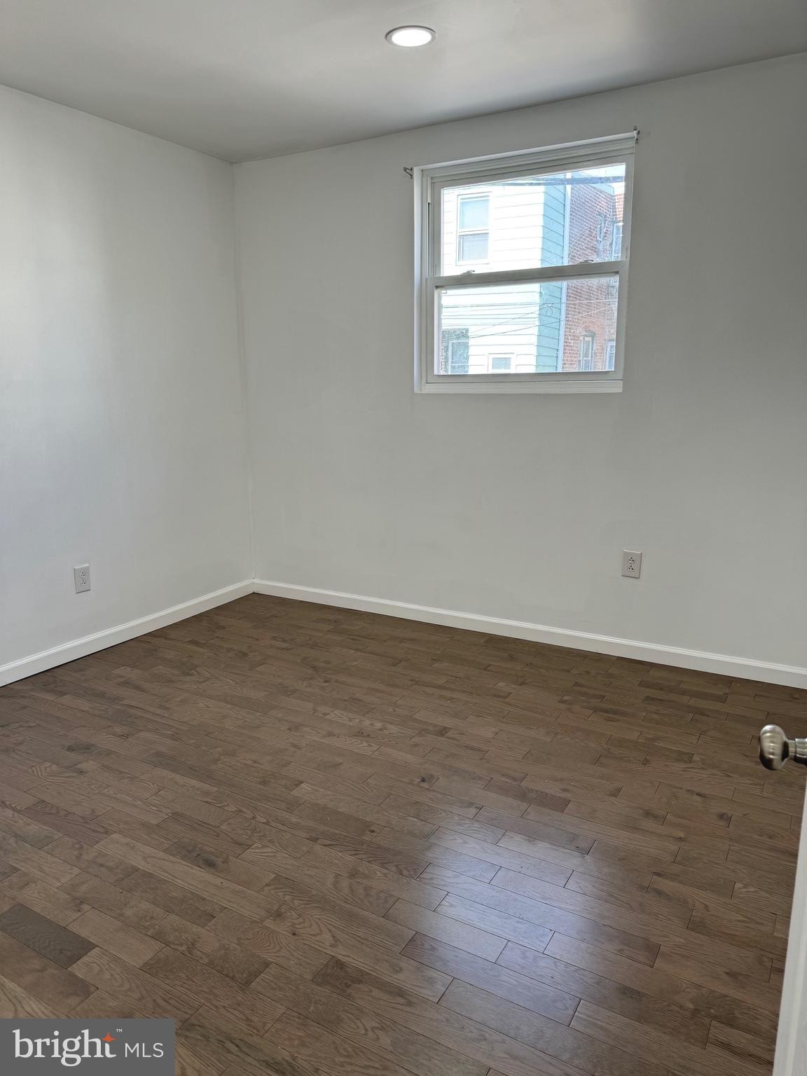 139 Rosemar Street Philadelphia, PA 19120 - Photo 15 of 19 an empty room with wooden floor and windows