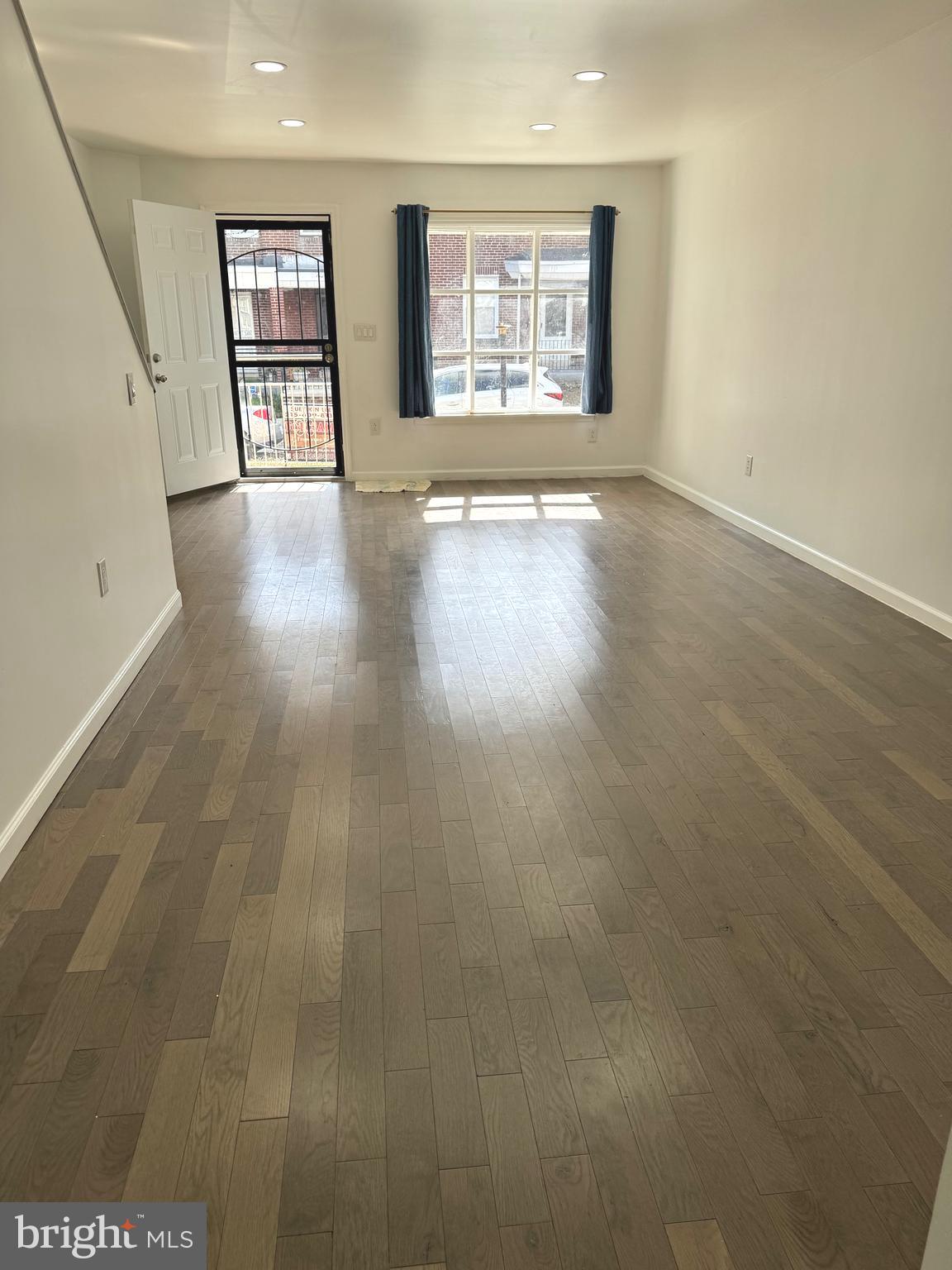 139 Rosemar Street Philadelphia, PA 19120 - Photo 4 of 19 an empty room with wooden floor and windows