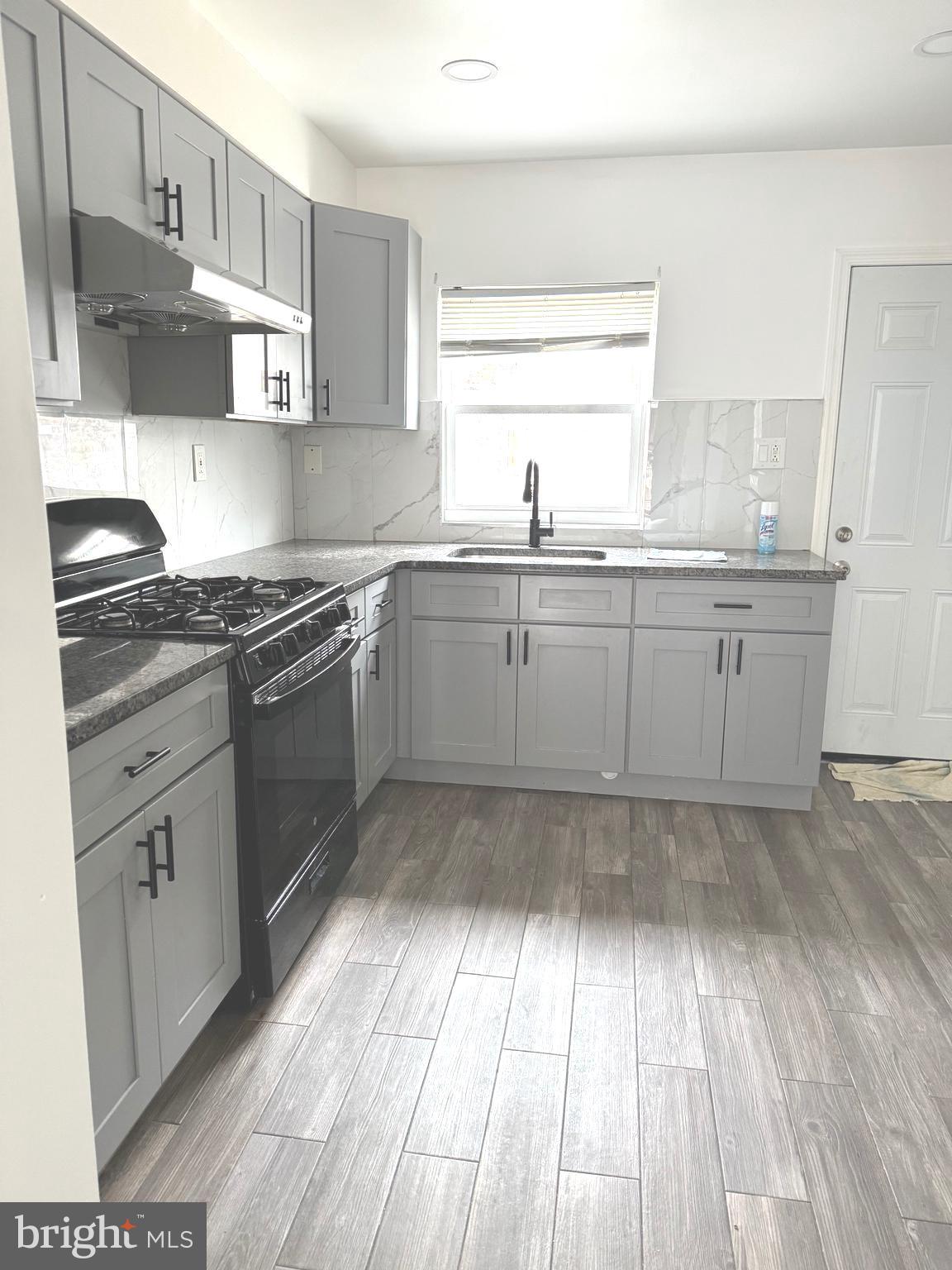 139 Rosemar Street Philadelphia, PA 19120 - Photo 6 of 19 a kitchen with granite countertop cabinets stainless steel appliances a sink and a window