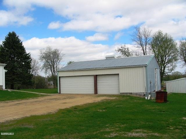 9815 West Raders Road Pearl City, IL 61062 - Photo 5 of 15 a small white house with a yard and garage