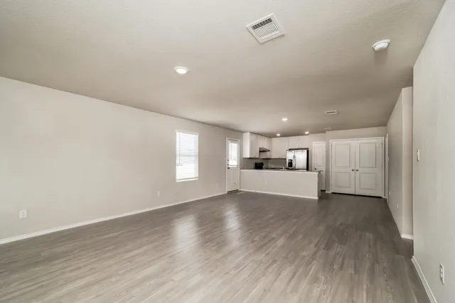 a view of empty room with wooden floor and window