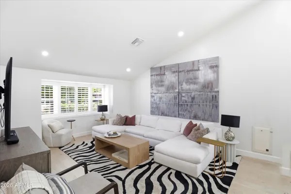a living room with furniture a flat screen tv and a large window