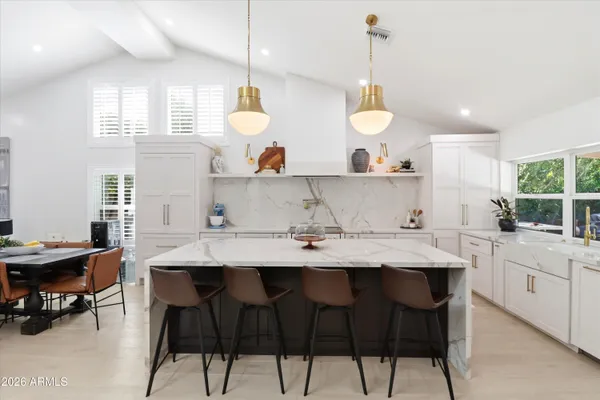 a kitchen with a stove a table and chairs in it