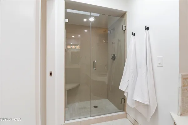 a bathroom with a granite countertop double vanity sink a mirror and a bathtub