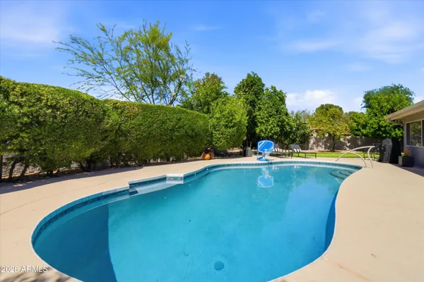 a front view of a house with swimming pool and sitting area