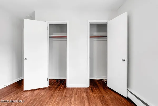 a view of walk in closet with wooden floor