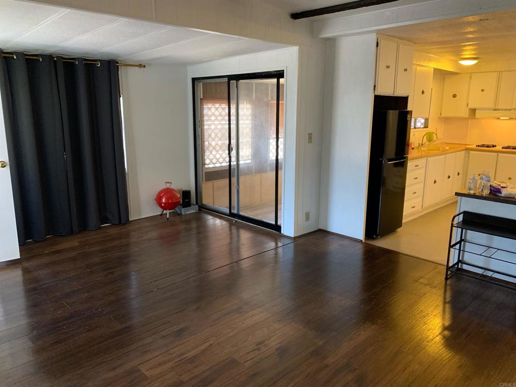 7 Lynn Lane Oceanside, CA 92058 - Photo 2 of 9 an empty room with wooden floor and windows