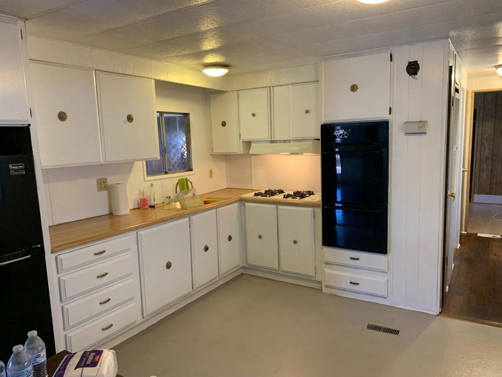 7 Lynn Lane Oceanside, CA 92058 - Photo 5 of 9 a kitchen with granite countertop white cabinets and refrigerator