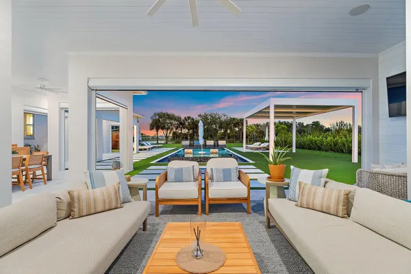 a view of a swimming pool with lawn chairs and a big yard