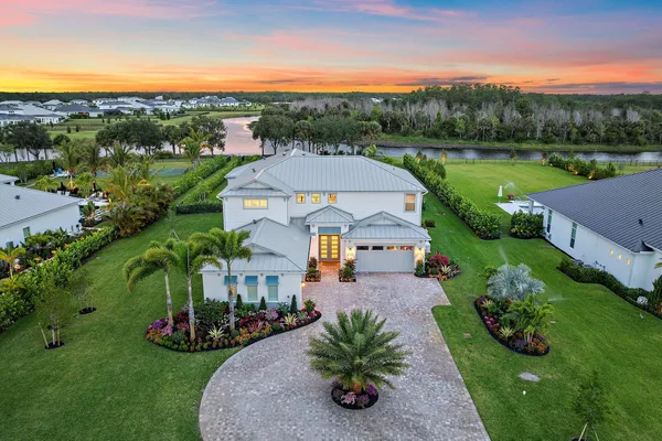 a kitchen with stainless steel appliances kitchen island granite countertop a table chairs in it and wooden floors