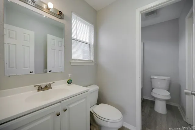 a bathroom with a sink a toilet and a window