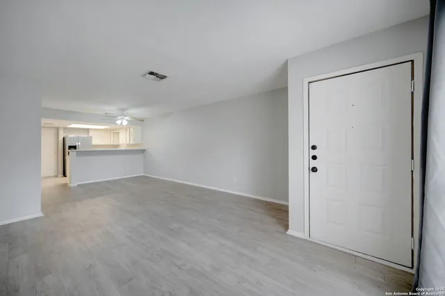 a view of empty room with wooden floor and entryway