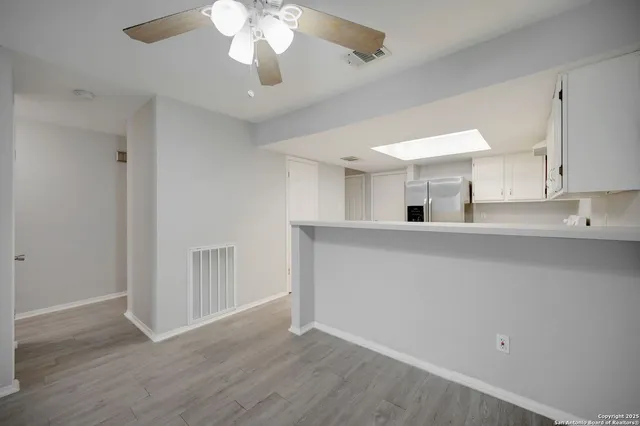 a view of a kitchen with a sink dishwasher a refrigerator with wooden floor and cabinets