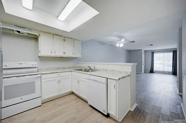 a kitchen with a sink cabinets and wooden floor