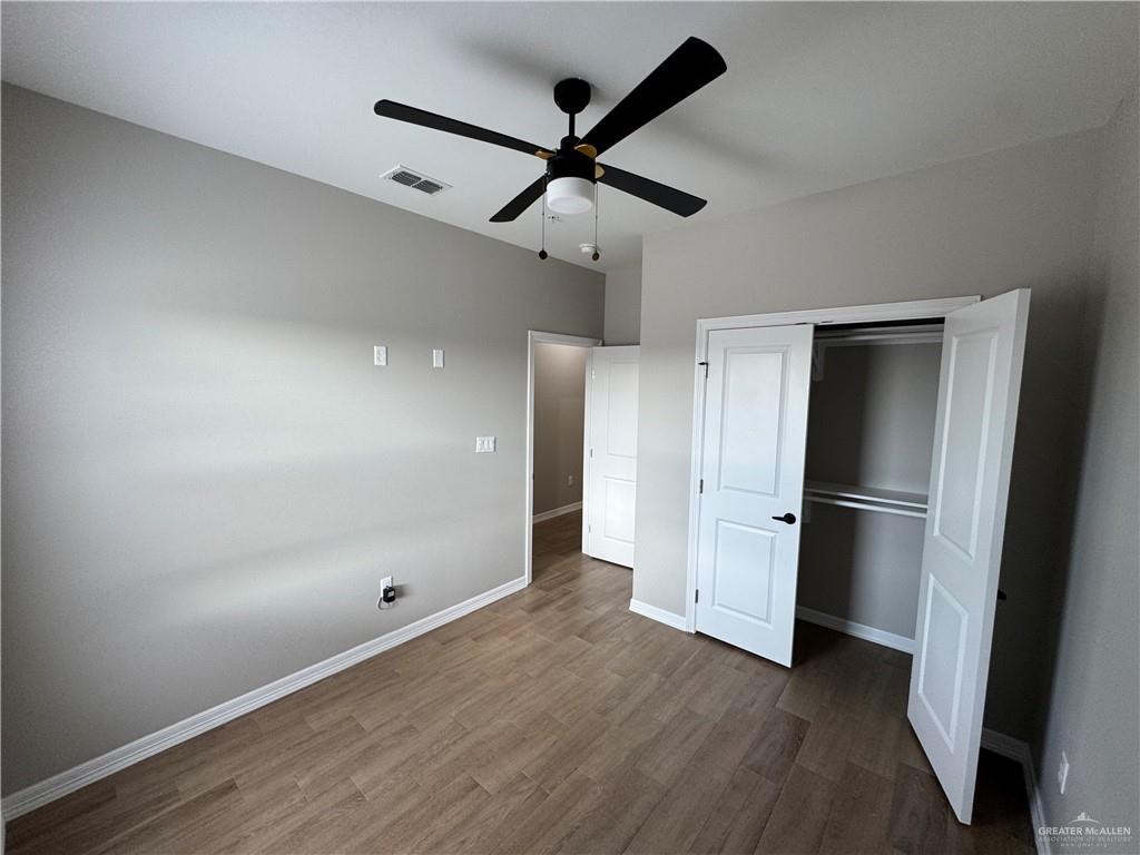 800 Ragland Road, Unit 9 Mission, TX 78572 - Photo 11 of 16 a view of a hallway with wooden floor and a ceiling fan
