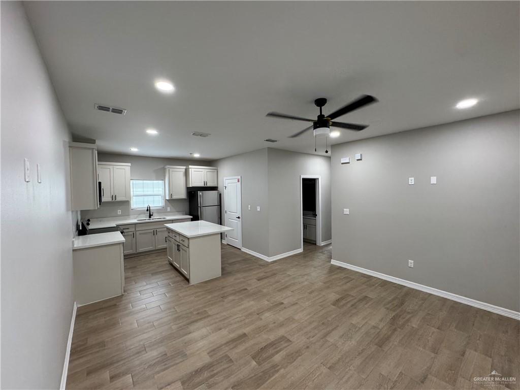 800 Ragland Road, Unit 9 Mission, TX 78572 - Photo 6 of 16 a kitchen with a sink dishwasher a stove and a refrigerator with wooden floor