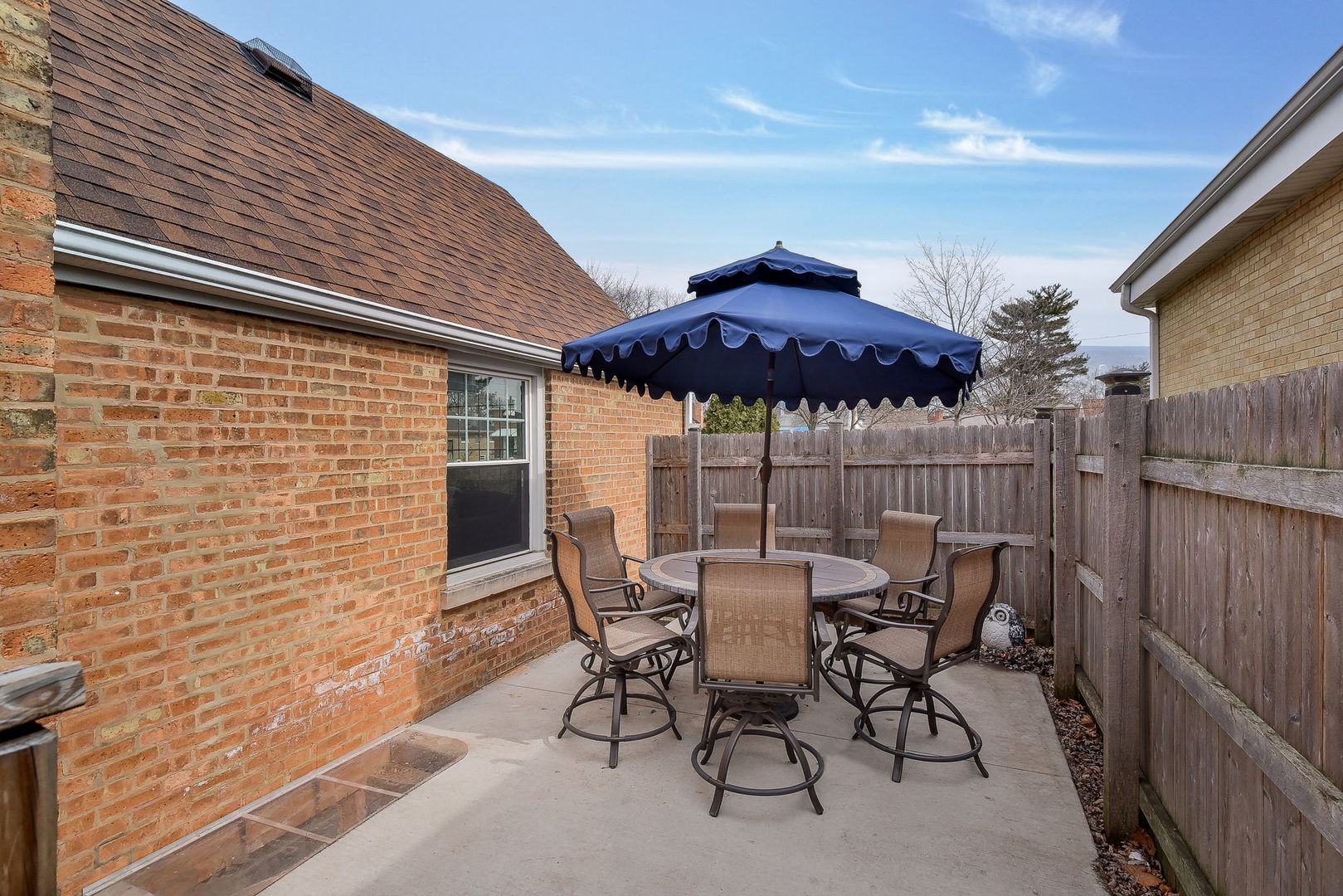 1500 Lee Boulevard Berkeley, IL 60163 - Photo 22 of 22 a view of a patio with a table and chairs under an umbrella with wooden fence