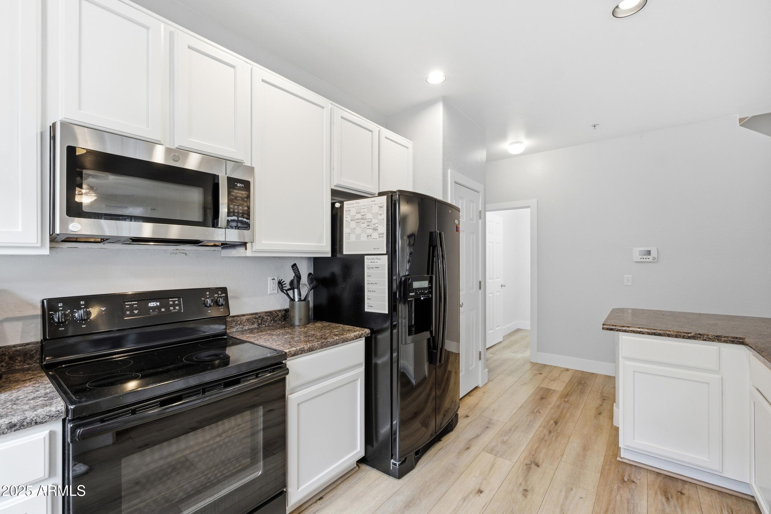1255 South Rialto, Unit 162 Mesa, AZ 85209 - Photo 11 of 27 a kitchen with appliances a stove cabinets and a wooden floor